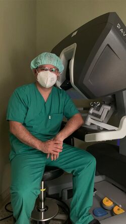 Bild Dr Daniel Valdivia sitzt vor dem da Vinci Robotersystem