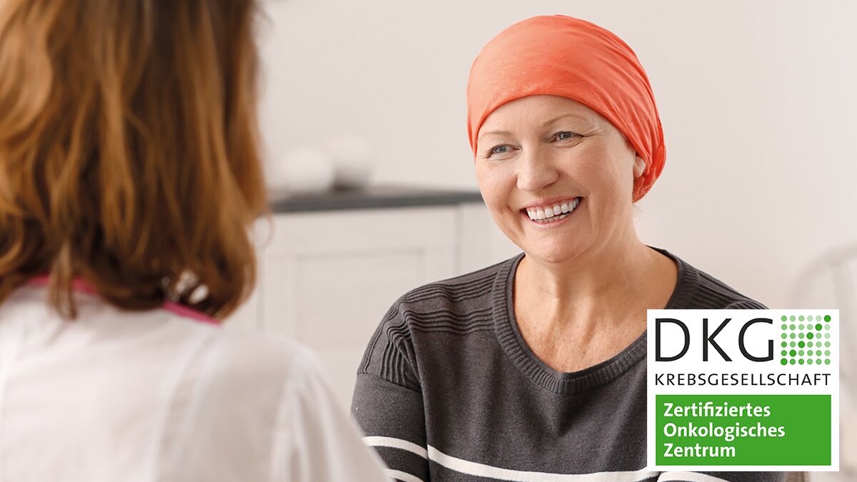 Foto: Krebspatientin mit Kopftuch im Gespräch mit einer Ärztin