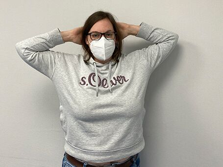 Bild Patientin Schulterinstabilität verschränkt die Arme hinter dem Kopf