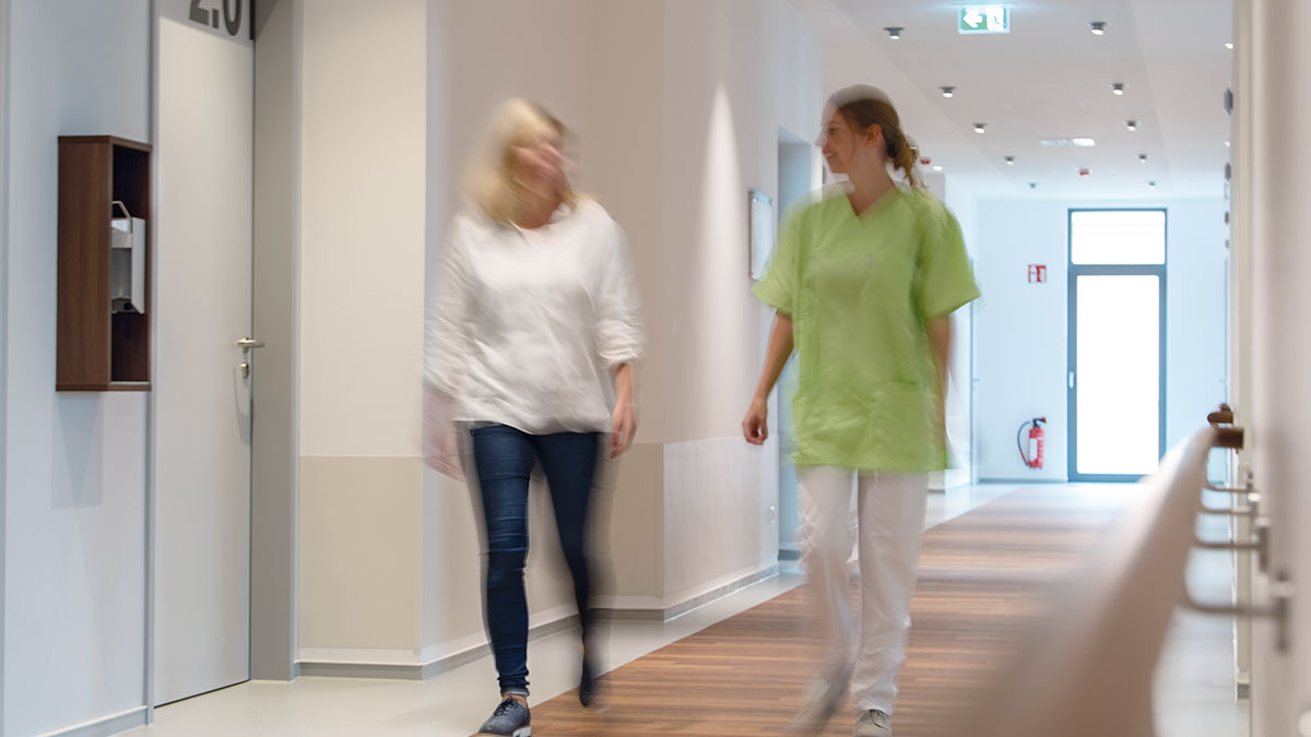 Bild von zwei Frauen die über den Flur der Komfortklinik gehen