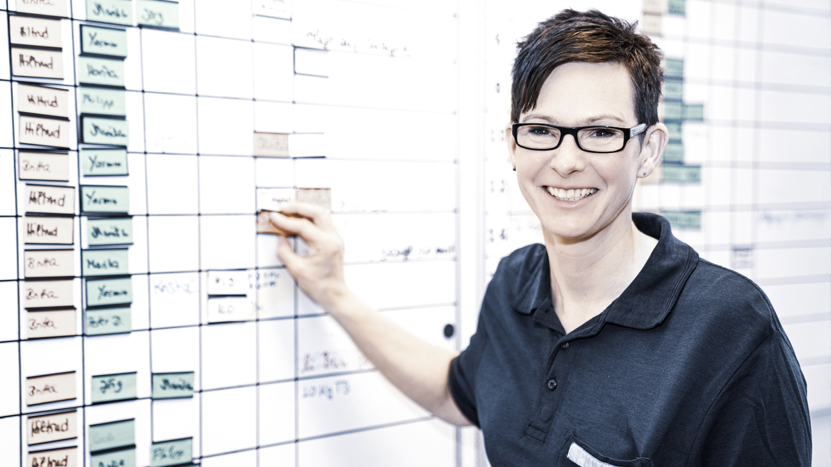 Bild von Mitarbeiterin vor Wandtafel